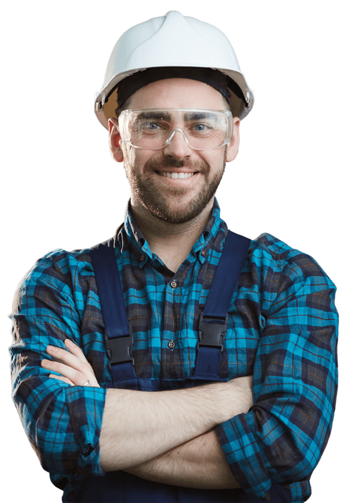 A male plumber wearing a safety hat and glasses smiling with his arms folded in front of him