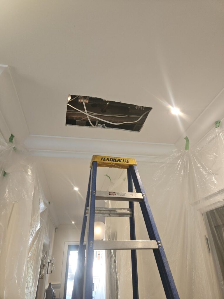 A ladder below a hole in the ceiling where Prostream Mechanical's completed a pipe repair at a customer's home